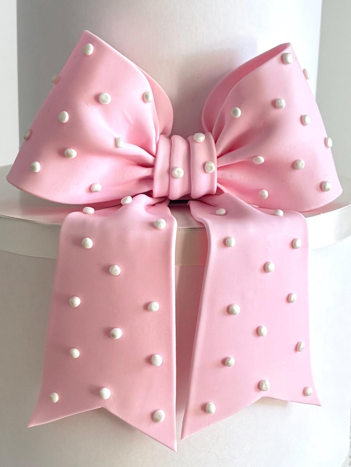 Big light pink fondant bow with pearl dots