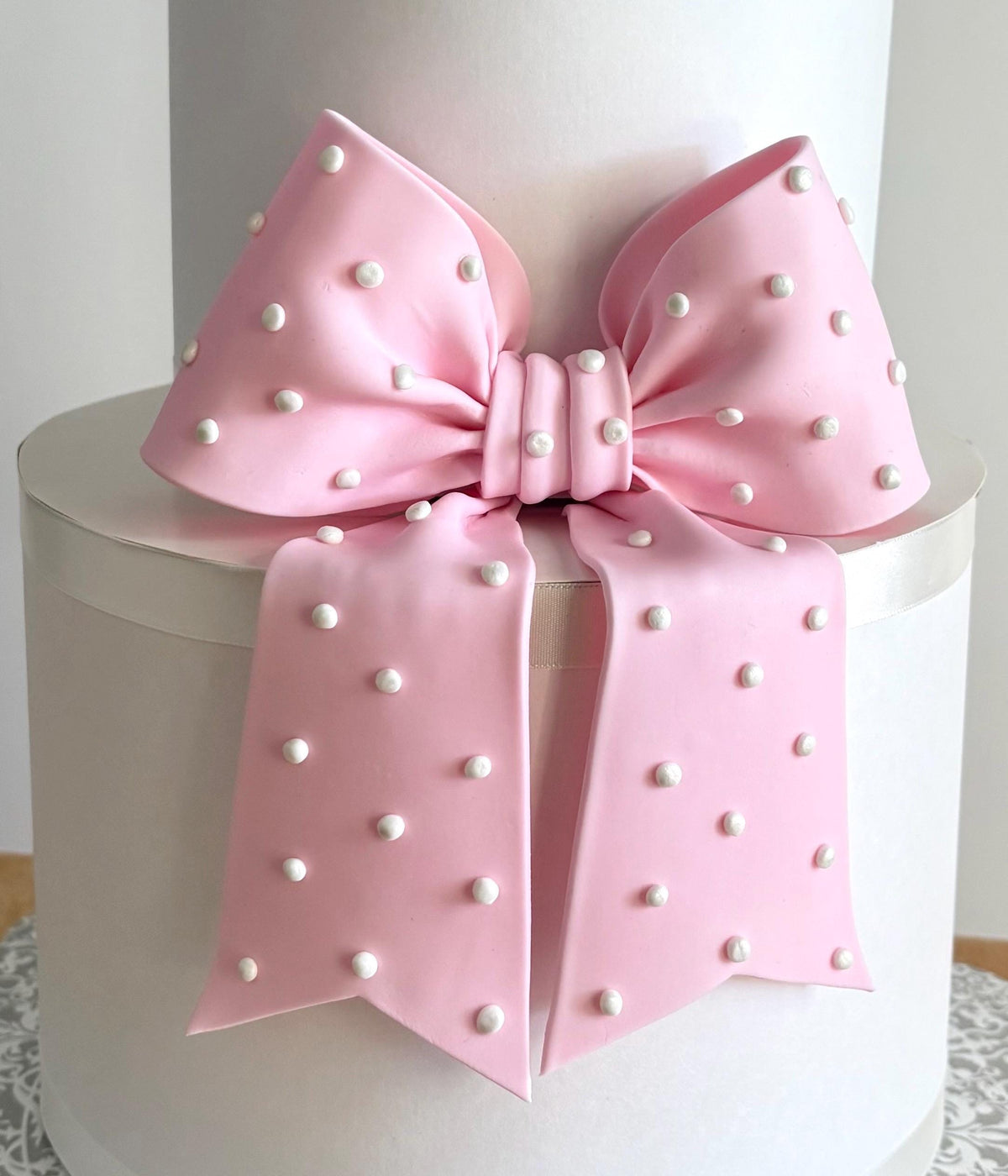 Big light pink fondant bow with pearl dots