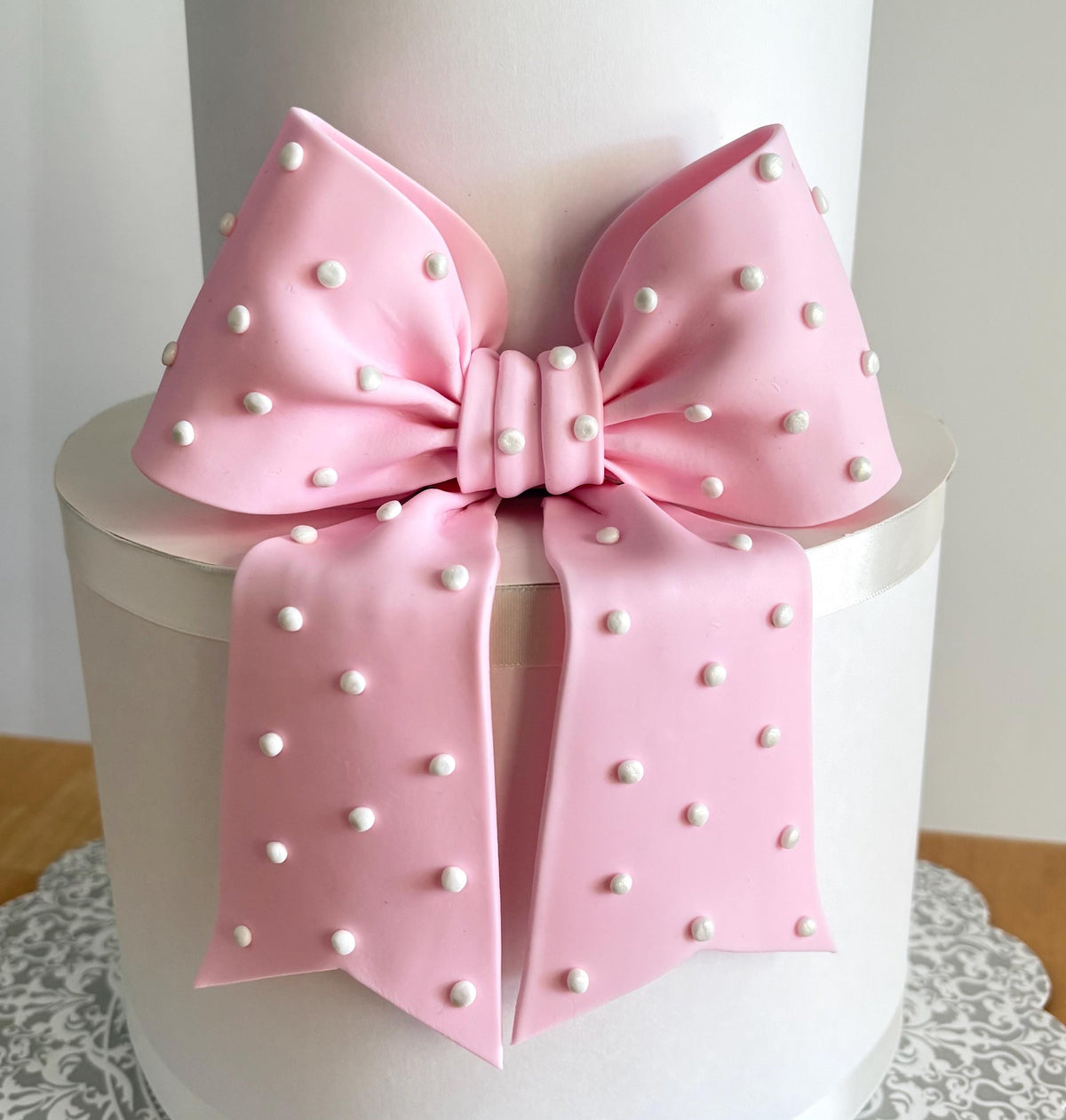 Big light pink fondant bow with pearl dots